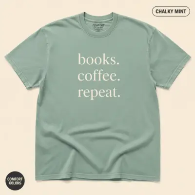Chalky mint Comfort Colors garment-dyed tee with minimalist Books Coffee Repeat typographic print, studio frontal view