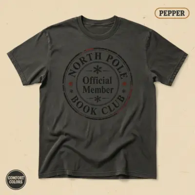 North Pole Book Club Christmas bookish t-shirt in Pepper garment-dyed Comfort Colors 1717 – front studio view with holiday reader graphic