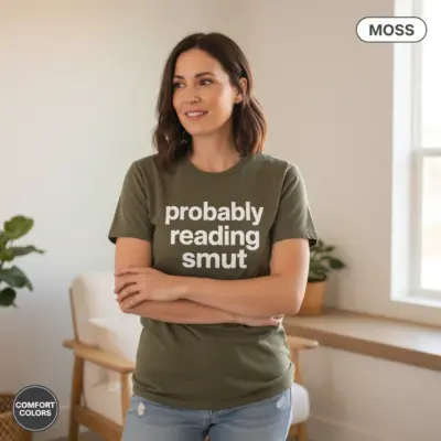 Moss Comfort Colors garment-dyed tee with "Probably Reading Smut" bold typography – worn casually indoors by female model