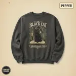 Pepper garment-dyed crewneck sweatshirt with woodcut black cat graphic and gothic Edgar Allan Poe typography on front chest